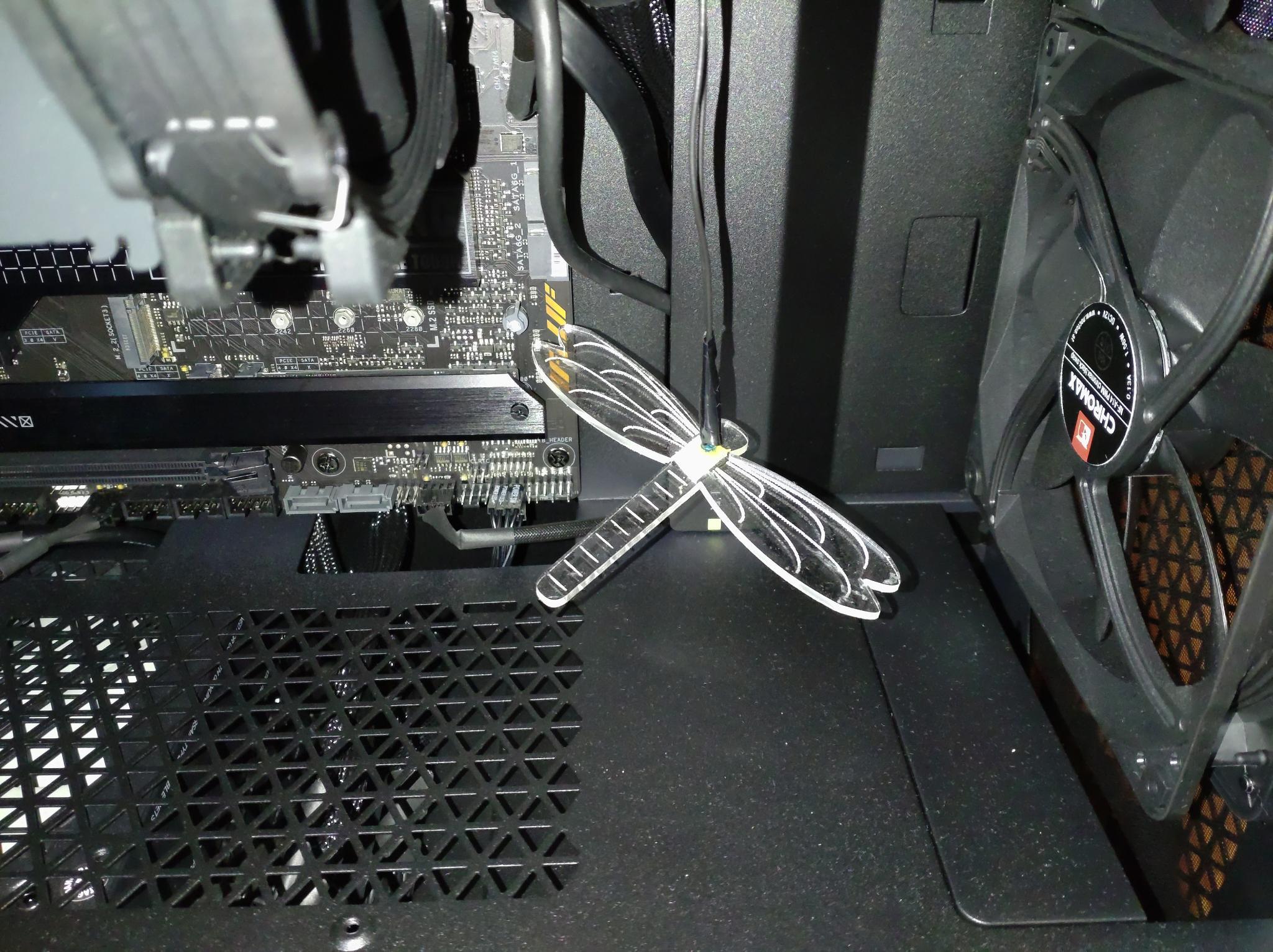 an acrylic dragonfly hanging in an open PC case