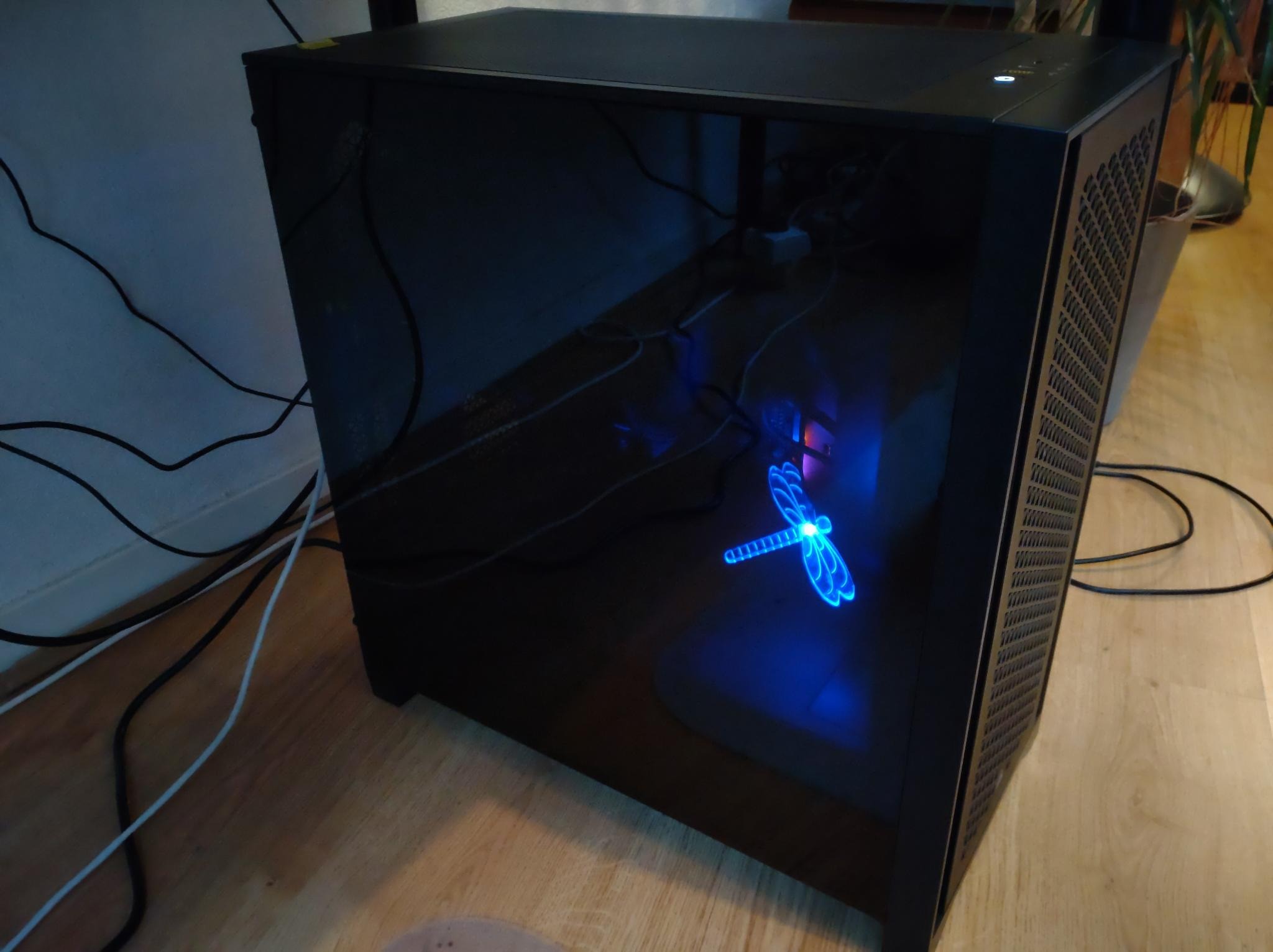 A PC case with a blue glowing dragonfly inside